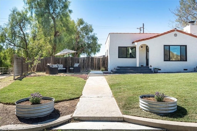 mediterranean / spanish home featuring a fenced backyard, a chimney, an outdoor hangout area, a front lawn, and stucco siding