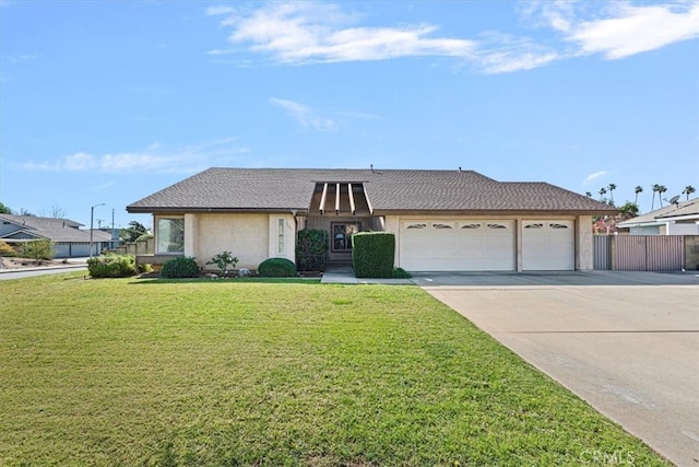 view of front of property featuring an attached garage, fence, concrete driveway, stucco siding, and a front yard