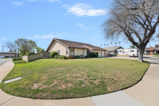 view of home's exterior with driveway, a lawn, an attached garage, and fence