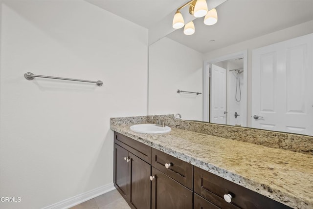 bathroom with a chandelier, tile patterned floors, vanity, and baseboards