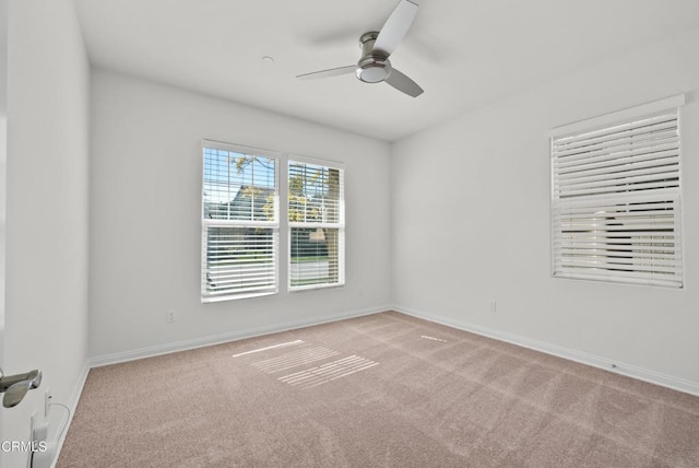 spare room with carpet, a ceiling fan, and baseboards