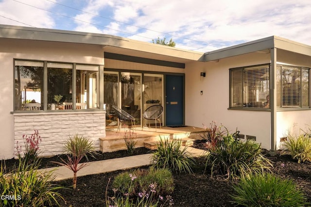 entrance to property featuring stucco siding