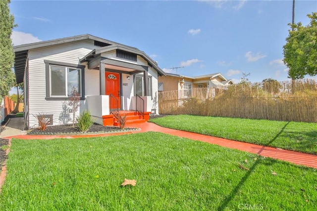 bungalow-style house featuring a front yard and fence