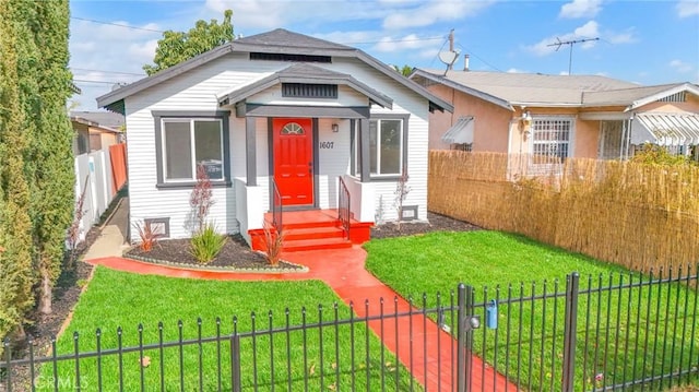 bungalow-style house with a front lawn and a fenced front yard