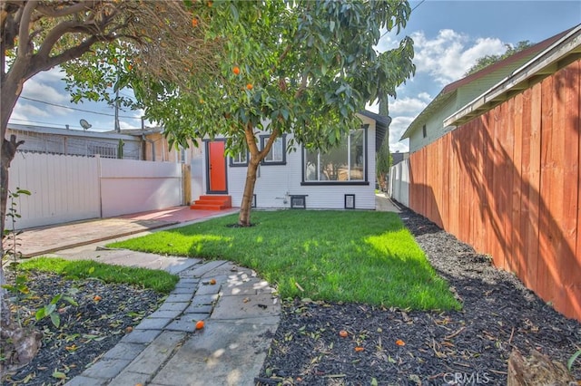 exterior space with entry steps, fence, and a yard