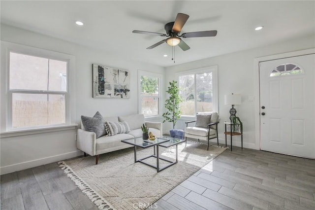 living room featuring recessed lighting, ceiling fan, baseboards, and wood finished floors