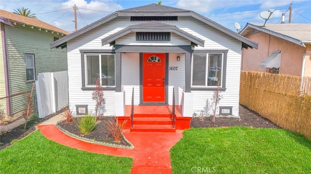 view of front facade with a front lawn and fence