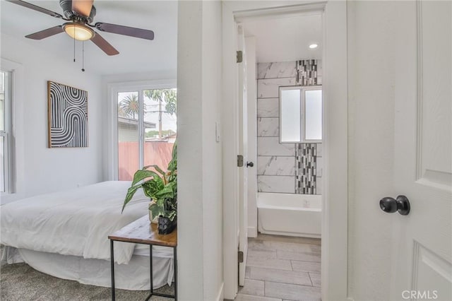 bedroom with ensuite bath and a ceiling fan