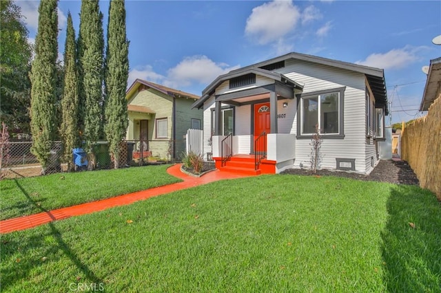 bungalow with a front yard and fence