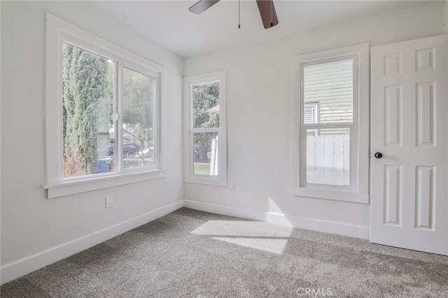 unfurnished room featuring carpet flooring, ceiling fan, and baseboards