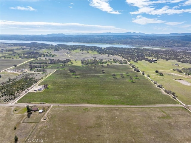 drone / aerial view with a water and mountain view and a rural view