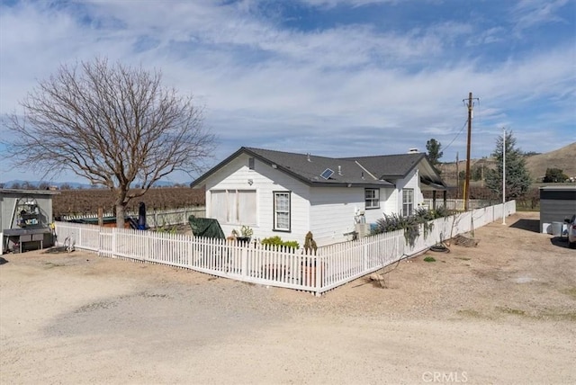 bungalow-style home featuring driveway and a fenced front yard