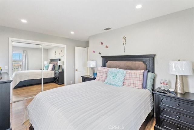 bedroom featuring recessed lighting, a closet, visible vents, and wood finished floors