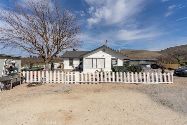 bungalow-style house with a fenced front yard and a mountain view