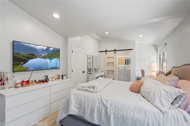 bedroom with light wood-type flooring, lofted ceiling, recessed lighting, and a barn door