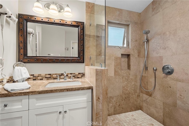 full bathroom with tasteful backsplash, a tile shower, and vanity