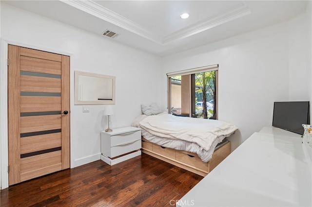 bedroom with dark wood-style floors, ornamental molding, a raised ceiling, and visible vents