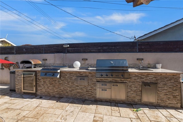 view of patio with a sink, fence, grilling area, and area for grilling