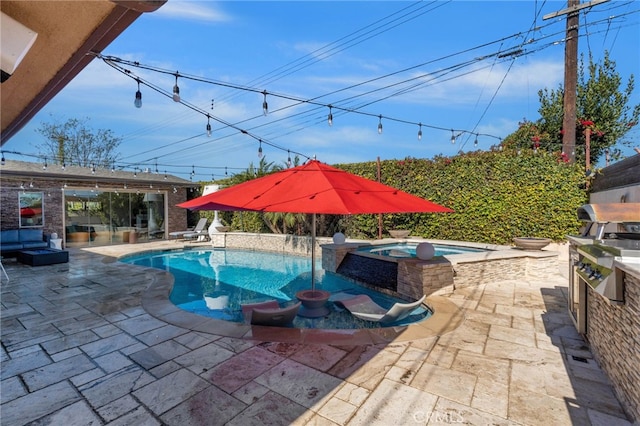 view of swimming pool featuring a pool with connected hot tub, a patio, and an outdoor kitchen