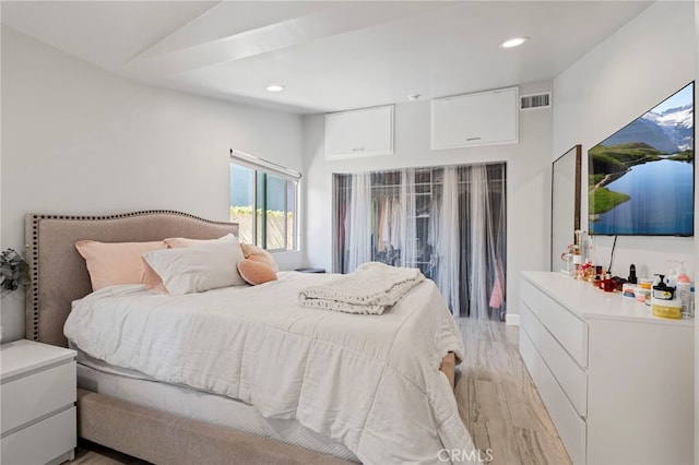 bedroom featuring light wood-style floors, lofted ceiling, visible vents, and recessed lighting