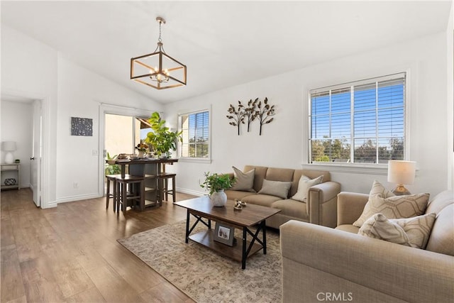 living room with vaulted ceiling, plenty of natural light, wood finished floors, and baseboards