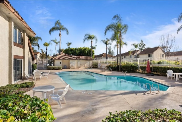 pool featuring a patio area, fence, and a residential view