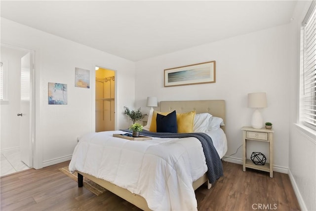 bedroom with baseboards and wood finished floors