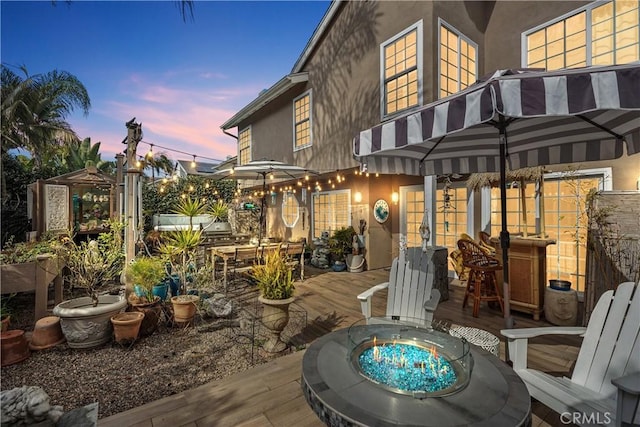 view of patio / terrace with a fire pit, french doors, and a wooden deck