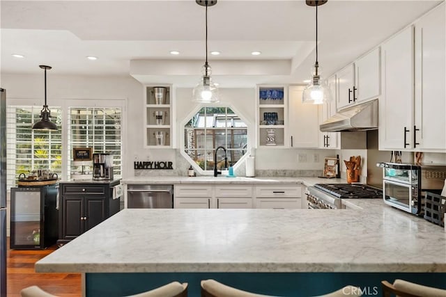 kitchen with under cabinet range hood, a sink, stainless steel dishwasher, range, and open shelves