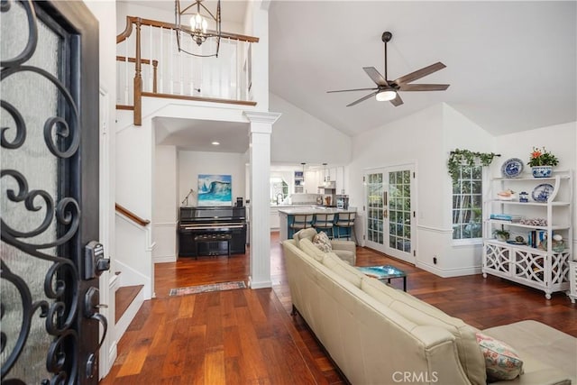 foyer featuring wood-type flooring, stairs, high vaulted ceiling, and ceiling fan with notable chandelier