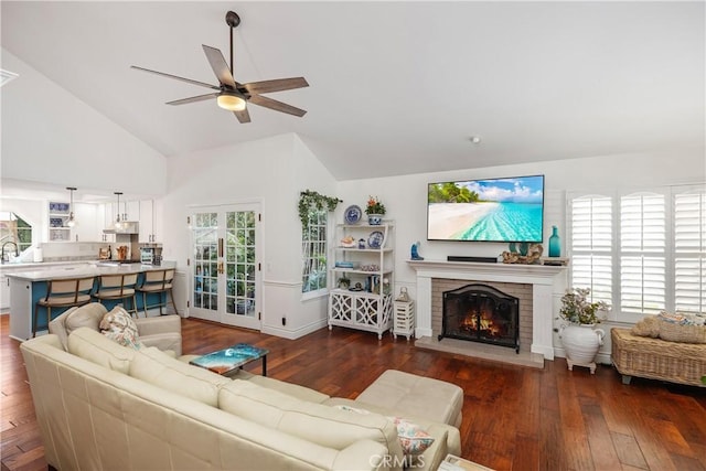 living area featuring a ceiling fan, a fireplace, hardwood / wood-style flooring, and a healthy amount of sunlight