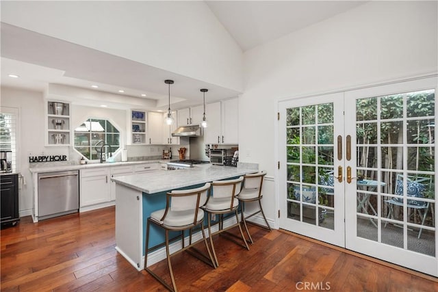 kitchen featuring open shelves, stainless steel dishwasher, white cabinets, under cabinet range hood, and a peninsula