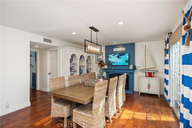 dining area featuring an inviting chandelier, baseboards, visible vents, and hardwood / wood-style floors