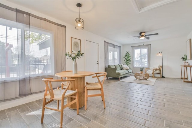 dining area with baseboards, a ceiling fan, and wood tiled floor