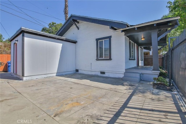 rear view of property featuring a patio, crawl space, and fence