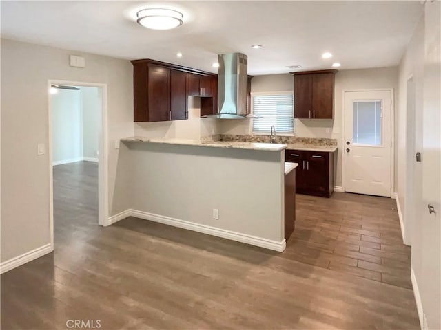 kitchen with dark brown cabinets, ventilation hood, dark wood-style flooring, and light countertops