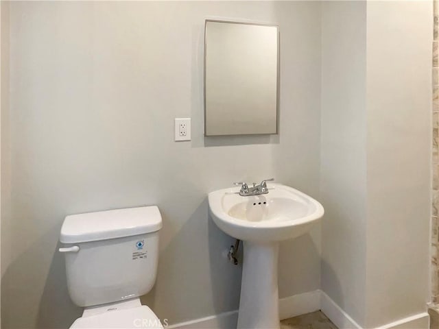 half bath with toilet and baseboards