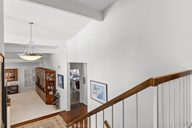 hallway featuring beam ceiling and an upstairs landing