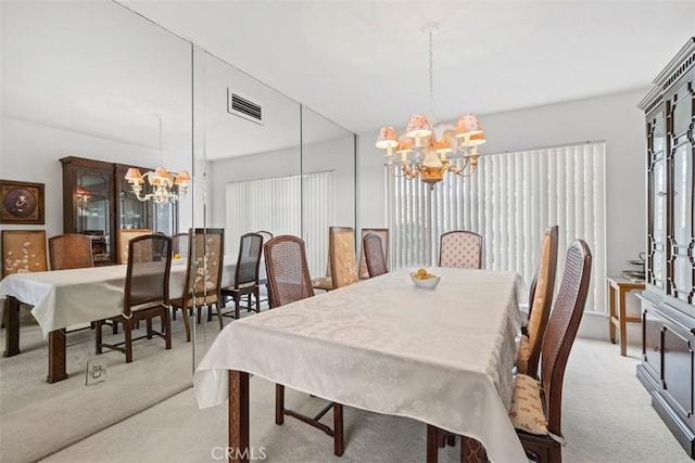 dining area with carpet floors, visible vents, and an inviting chandelier