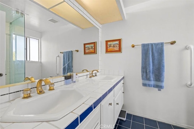 bathroom with double vanity, a sink, visible vents, and tile patterned floors