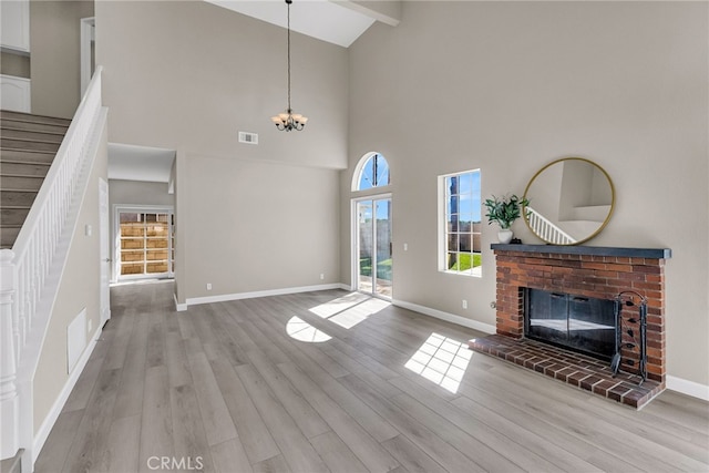 unfurnished living room featuring wood finished floors, a fireplace, baseboards, and stairs