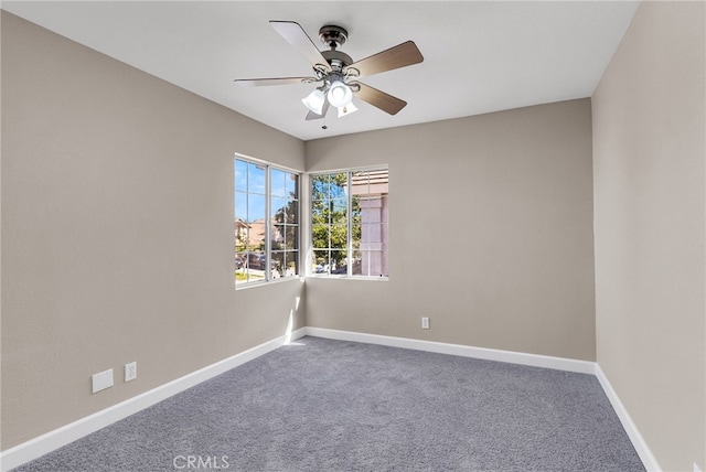 carpeted spare room with ceiling fan and baseboards