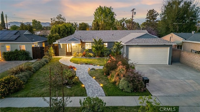 ranch-style home featuring stucco siding, driveway, an attached garage, and fence