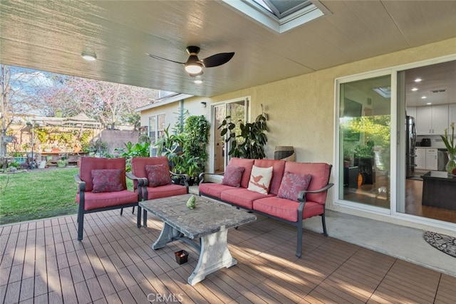 wooden terrace featuring an outdoor hangout area, a lawn, and ceiling fan