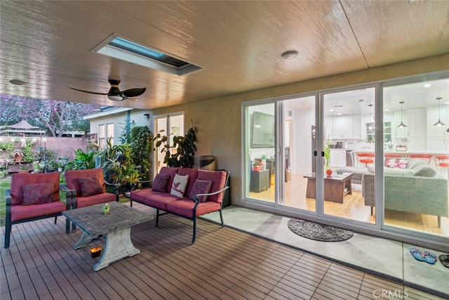 deck featuring an outdoor living space and a ceiling fan