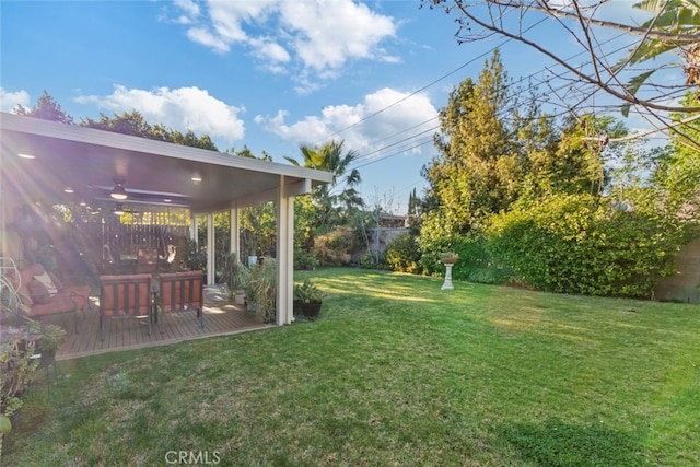 view of yard featuring a wooden deck, fence, and ceiling fan