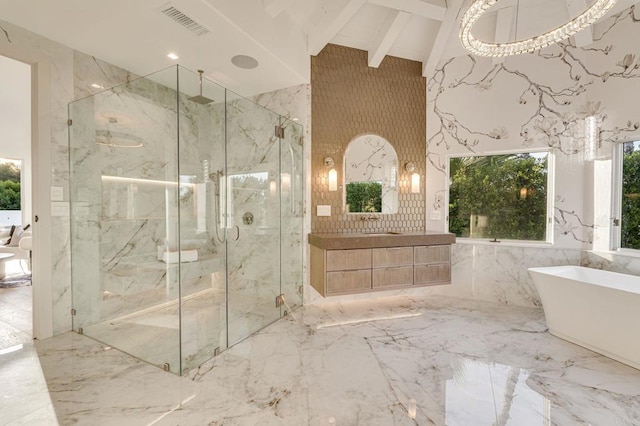 full bath with a marble finish shower, a soaking tub, marble finish floor, and stone wall