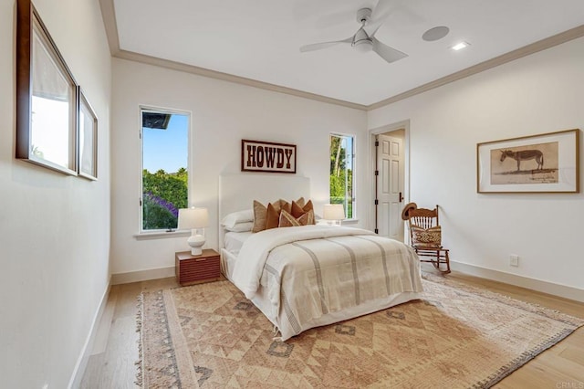 bedroom with light wood-style flooring, a ceiling fan, baseboards, and ornamental molding