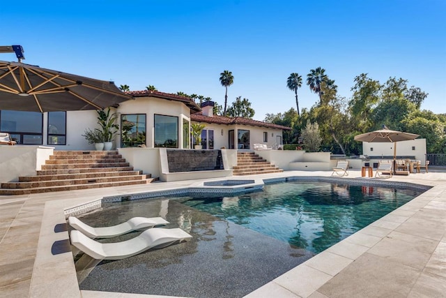 outdoor pool with stairs and a patio area