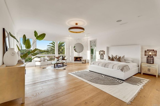 bedroom with hardwood / wood-style flooring and a fireplace